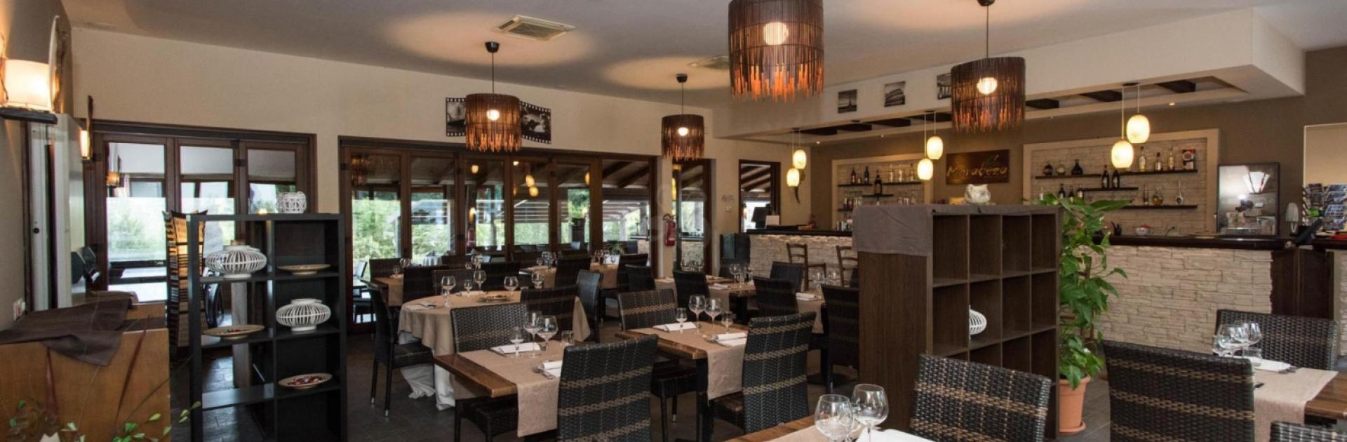 Modernes Restaurant mit eleganter Dekoration, Holzmöbeln und stimmungsvoller Beleuchtung.